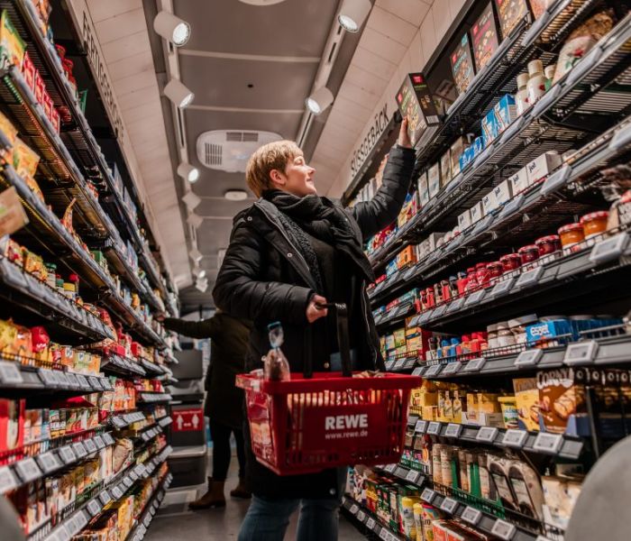 Eine Frau besucht den REWE-Einkaufs-Bus, um einzukaufen. (Foto: REWE)